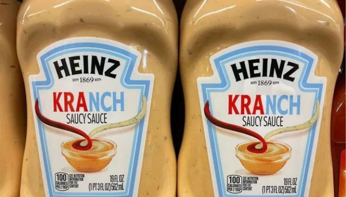 A crispy French fry being dipped into a creamy blend of Heinz Kranch sauce.