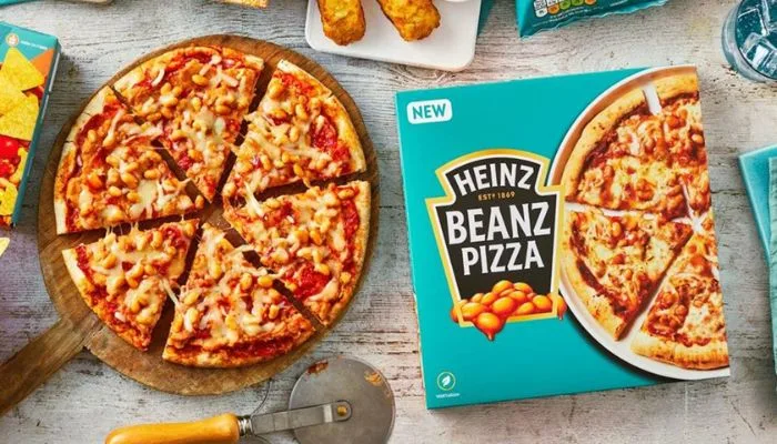 A frozen Heinz Beanz Pizza with a topping of baked beans, tomato sauce, and melted cheese.