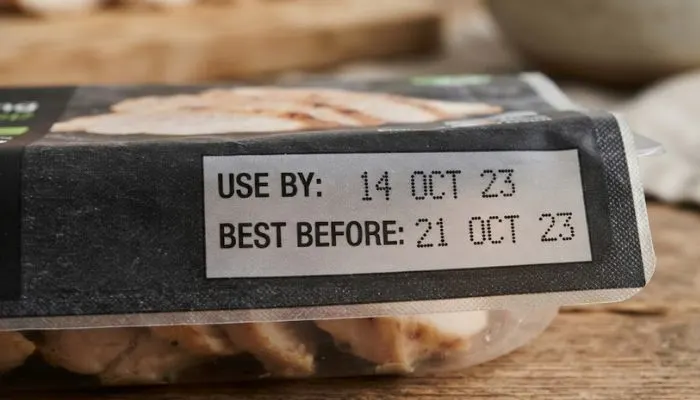 Close-up of a food product packaging showing the use-by and best-before expiration dates.